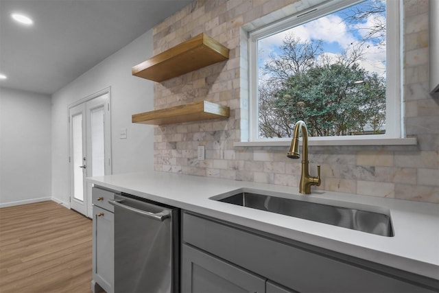 kitchen with sink, gray cabinets, dishwasher, and plenty of natural light