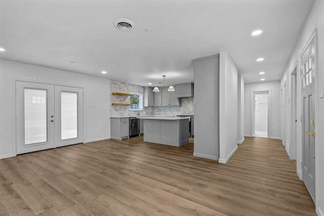 kitchen featuring gray cabinetry, hanging light fixtures, a center island, stainless steel appliances, and light wood-type flooring