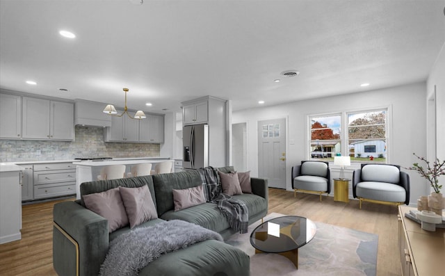 living room featuring recessed lighting, visible vents, and wood finished floors