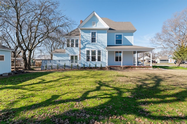 rear view of property featuring a porch, a yard, and a chimney