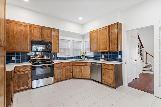 kitchen featuring decorative backsplash, appliances with stainless steel finishes, sink, and light tile patterned flooring