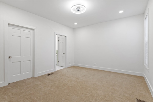 unfurnished room featuring light colored carpet