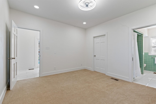 unfurnished room featuring light carpet