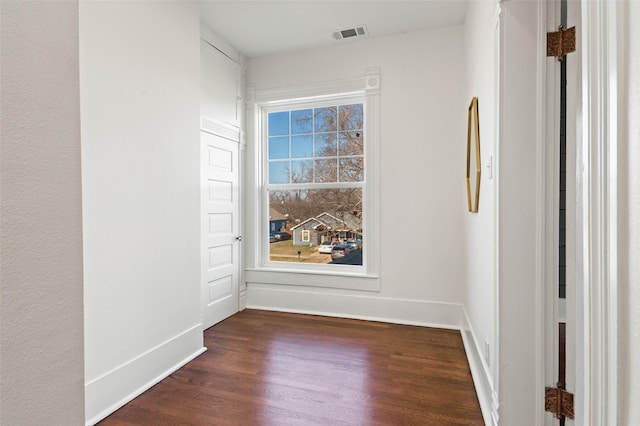 empty room with dark hardwood / wood-style flooring