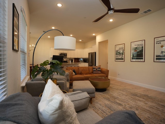 living room with ceiling fan and light hardwood / wood-style flooring