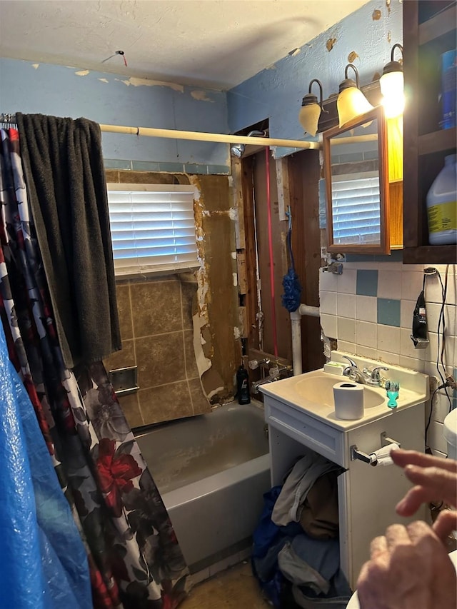 bathroom with vanity, plenty of natural light, shower / bathtub combination with curtain, and decorative backsplash