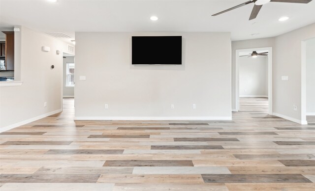 unfurnished living room featuring ceiling fan and light wood-type flooring