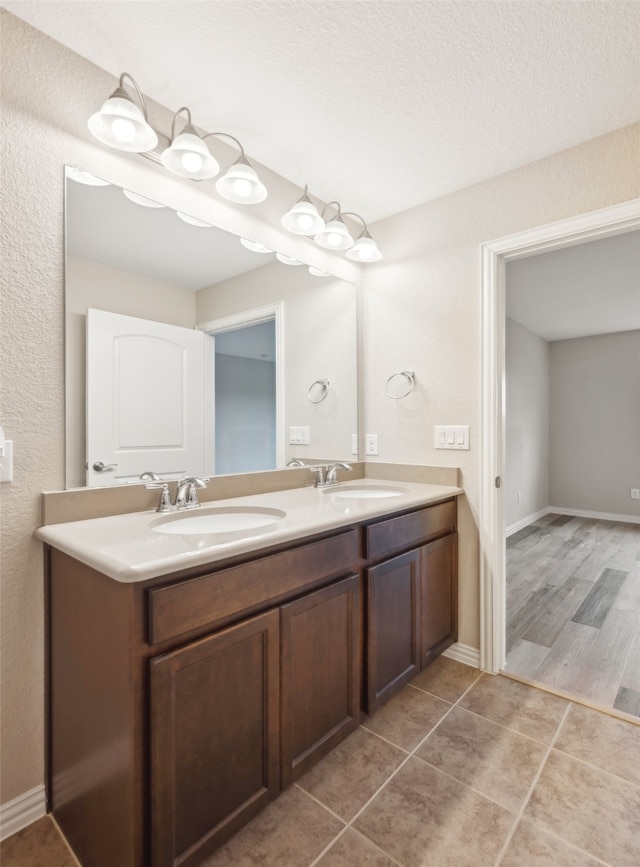 bathroom with hardwood / wood-style floors, vanity, and a textured ceiling