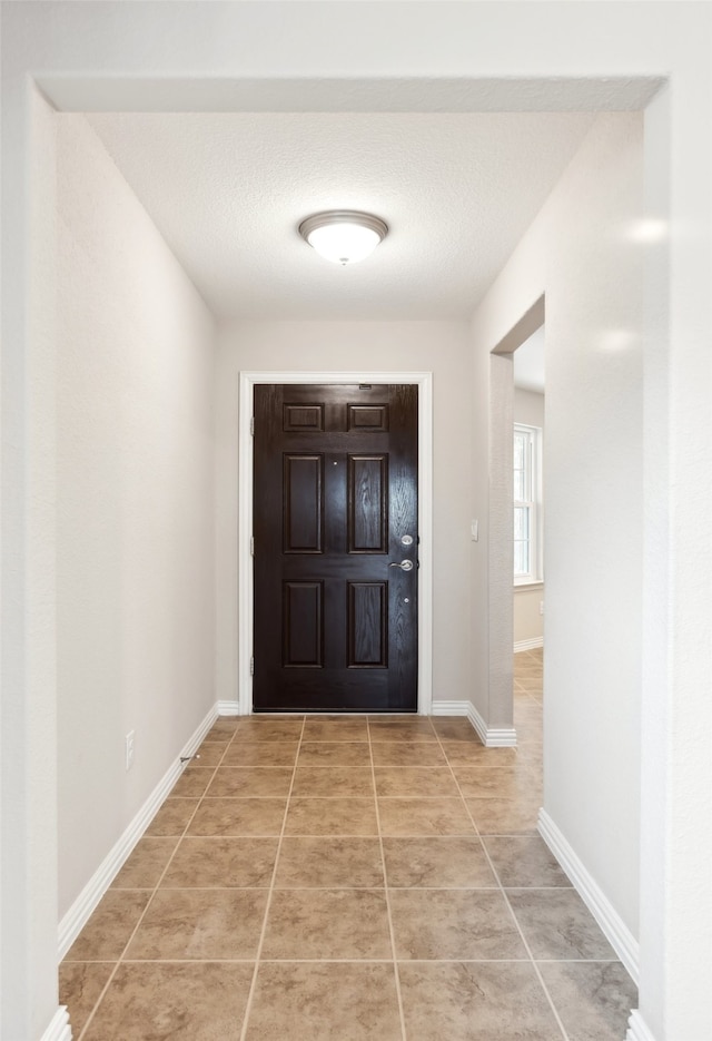 tiled entryway featuring a textured ceiling