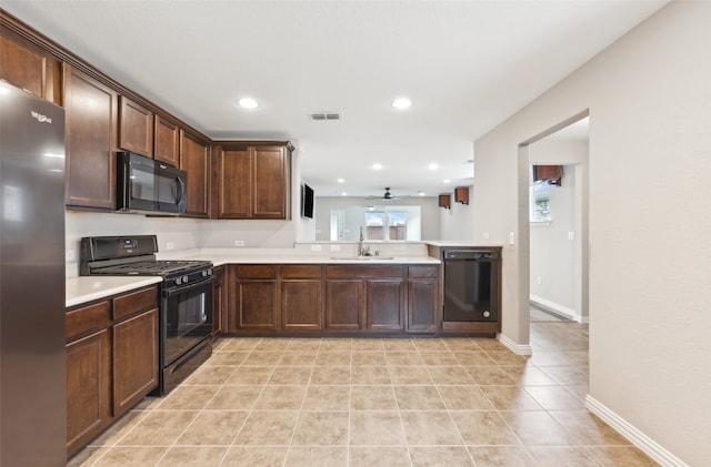 kitchen with ceiling fan, sink, kitchen peninsula, dark brown cabinets, and black appliances