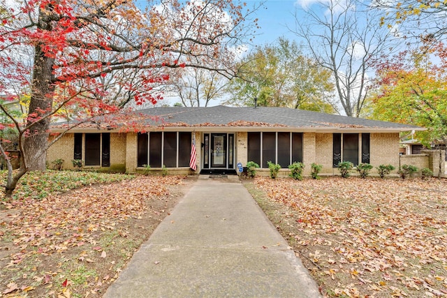 ranch-style house with brick siding and a sunroom