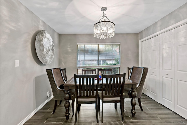 dining area with a chandelier, wood finish floors, and baseboards