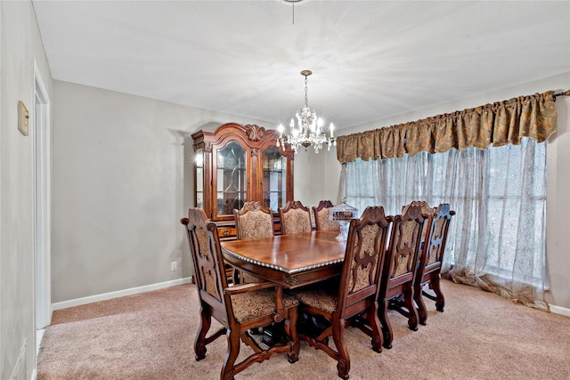 dining space featuring a chandelier, light carpet, and baseboards