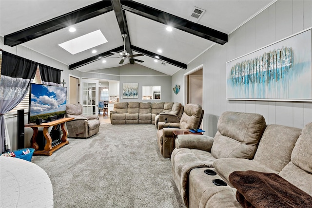 carpeted living room featuring lofted ceiling with skylight and ceiling fan