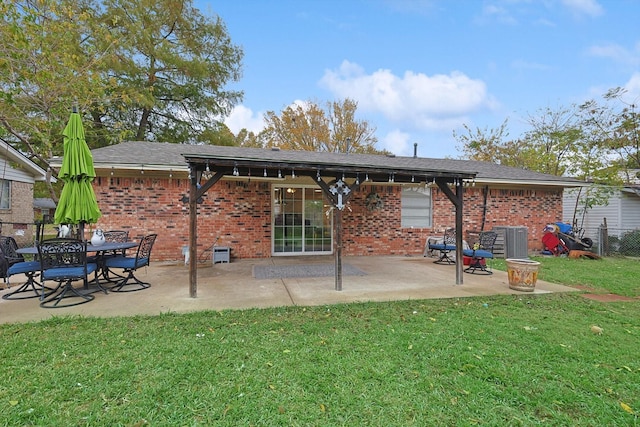 back of property with a patio area, a yard, and central AC