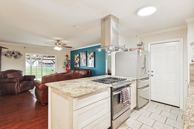 kitchen with gas stove, ceiling fan, crown molding, light hardwood / wood-style floors, and island range hood