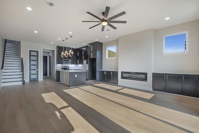 unfurnished living room featuring hardwood / wood-style floors and ceiling fan