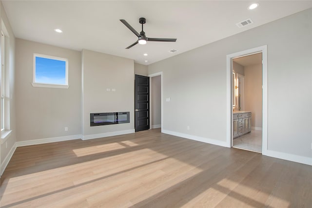 unfurnished living room featuring ceiling fan and light wood-type flooring