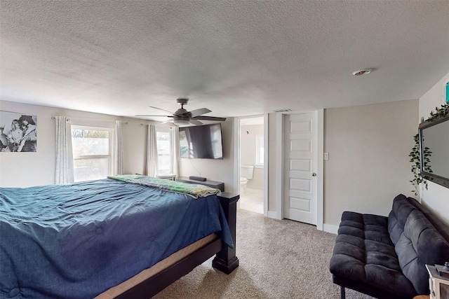 bedroom with light carpet, a textured ceiling, ensuite bath, and ceiling fan