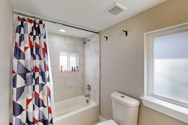 bathroom featuring shower / bath combination with curtain and toilet