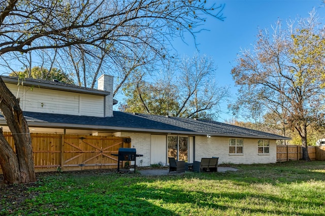 rear view of property featuring a lawn