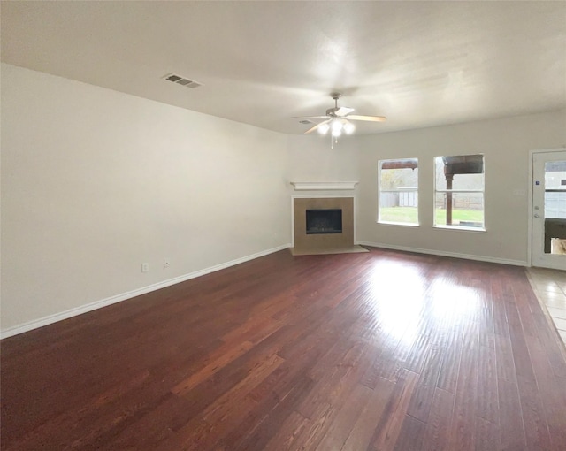 unfurnished living room featuring dark wood-type flooring and ceiling fan