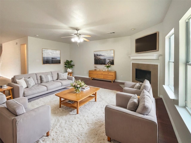 living room with a wealth of natural light, dark hardwood / wood-style floors, and ceiling fan