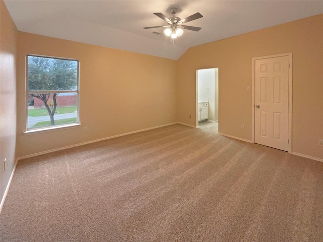 spare room with lofted ceiling, light carpet, and ceiling fan