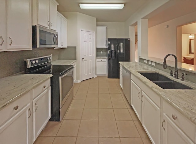 kitchen featuring sink, white cabinets, light tile patterned floors, light stone counters, and stainless steel appliances