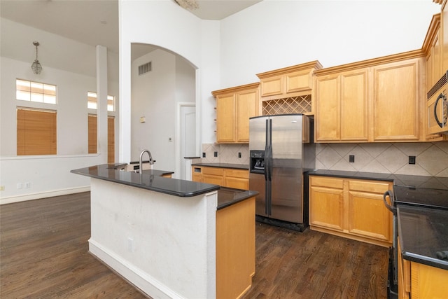 kitchen with dark hardwood / wood-style flooring, stainless steel refrigerator with ice dispenser, a high ceiling, and black stove