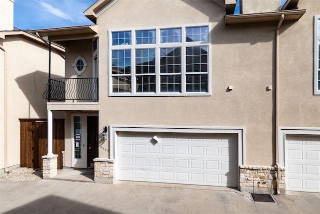 view of property with a balcony and a garage