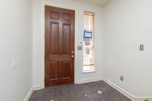 tiled entrance foyer featuring a healthy amount of sunlight