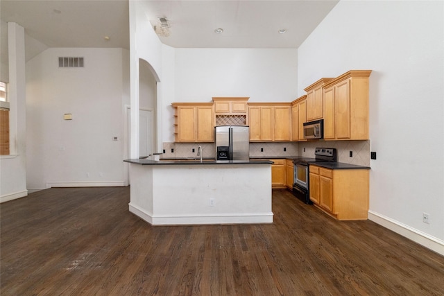 kitchen featuring dark hardwood / wood-style floors, light brown cabinets, and appliances with stainless steel finishes