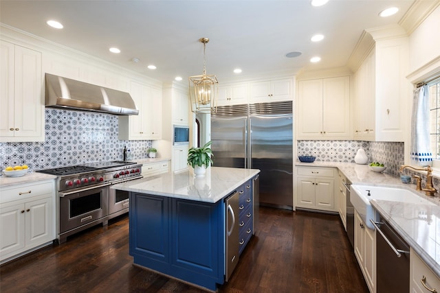 kitchen featuring premium appliances, a center island, dark wood-type flooring, and wall chimney range hood