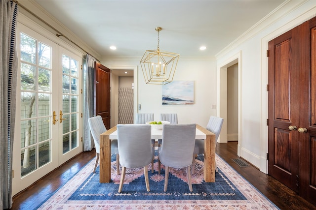 dining area featuring a notable chandelier, dark hardwood / wood-style flooring, ornamental molding, and french doors