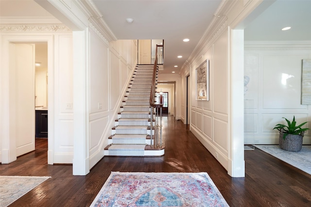 stairs featuring wood-type flooring and ornamental molding