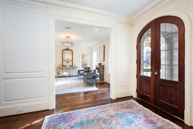 entryway with french doors, crown molding, plenty of natural light, and dark wood-type flooring