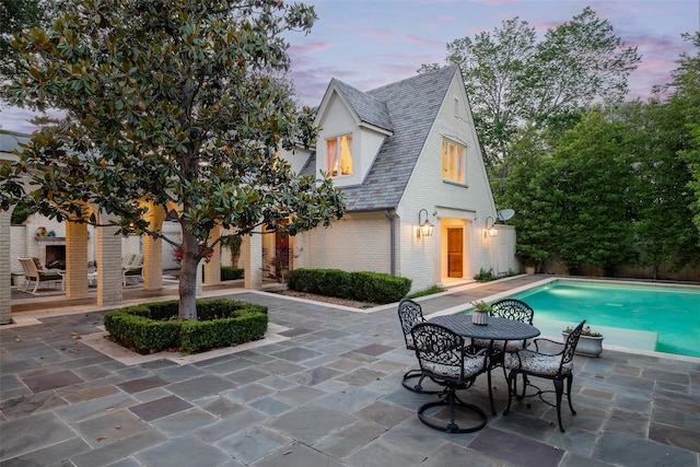 pool at dusk with a patio area