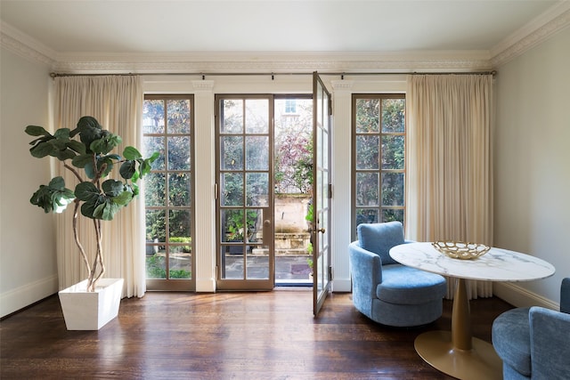 living area with dark hardwood / wood-style flooring, a wealth of natural light, and ornamental molding