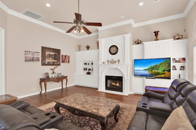 living room with dark hardwood / wood-style floors, ceiling fan, crown molding, and a high ceiling