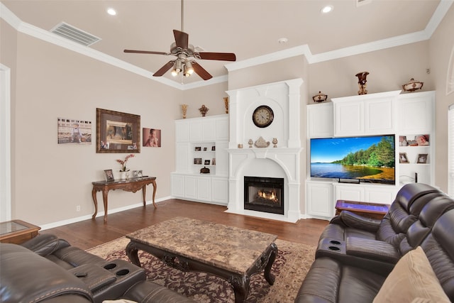 living room featuring dark wood-type flooring, ceiling fan, and ornamental molding