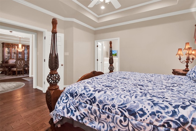 bedroom featuring ceiling fan with notable chandelier, dark hardwood / wood-style floors, a raised ceiling, and crown molding