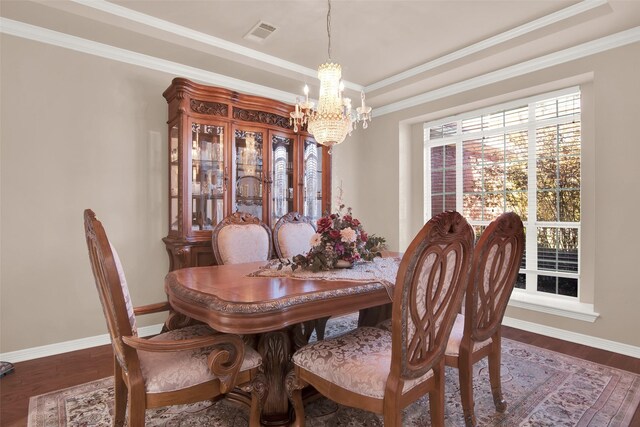 dining area featuring crown molding, dark wood-type flooring, a notable chandelier, and a tray ceiling