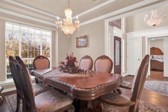 dining area with dark hardwood / wood-style floors, ornamental molding, a tray ceiling, and a chandelier