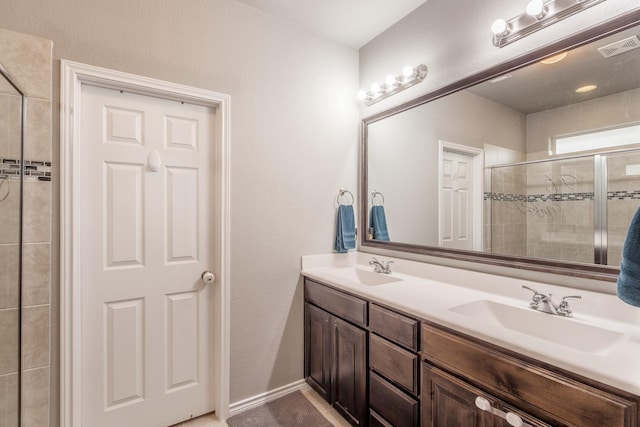 bathroom featuring a shower with door and vanity