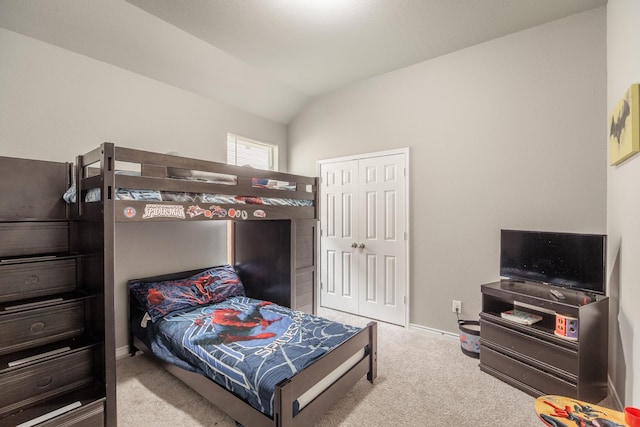 carpeted bedroom with lofted ceiling and a closet