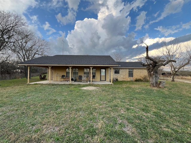 rear view of property with a yard and a patio area