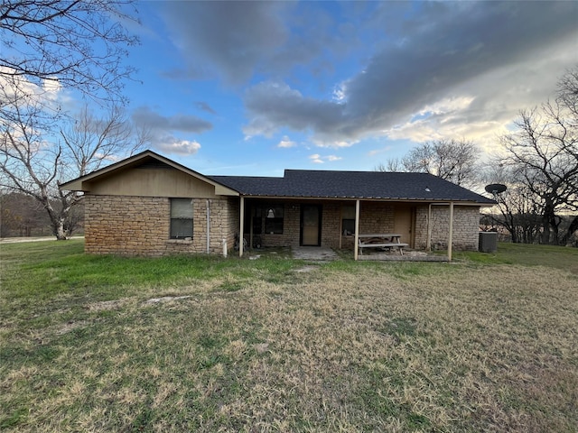 view of front of house with central AC unit and a front yard