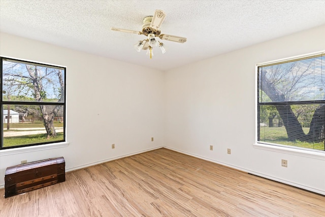 unfurnished room featuring ceiling fan, light hardwood / wood-style floors, and a textured ceiling