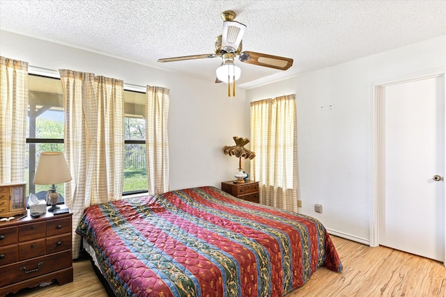 bedroom with multiple windows, ceiling fan, and light wood-type flooring